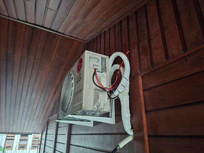 Unidade externa de ar-condicionado instalada sob telhado