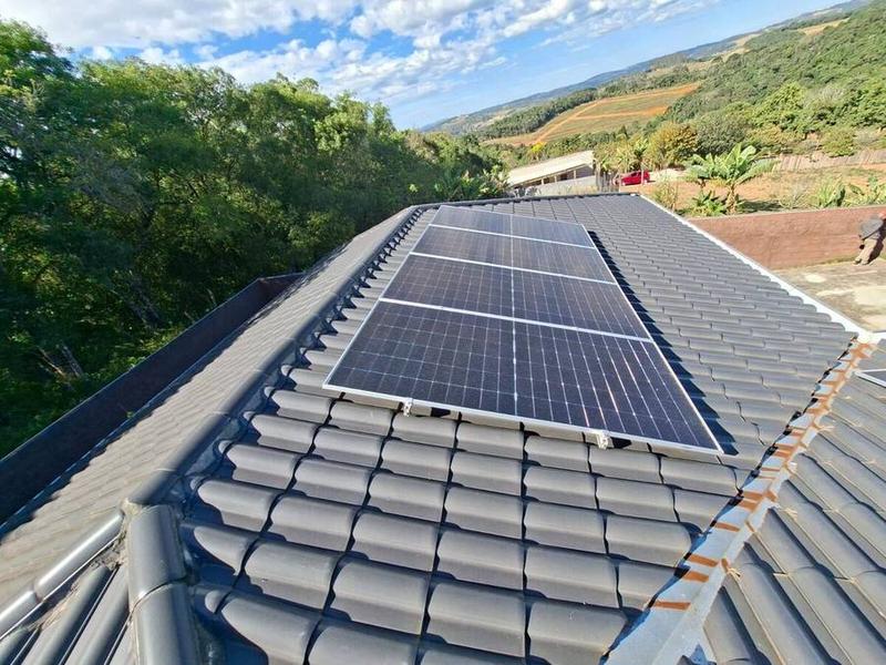Painéis solares instalados em telhado com vista para o vale