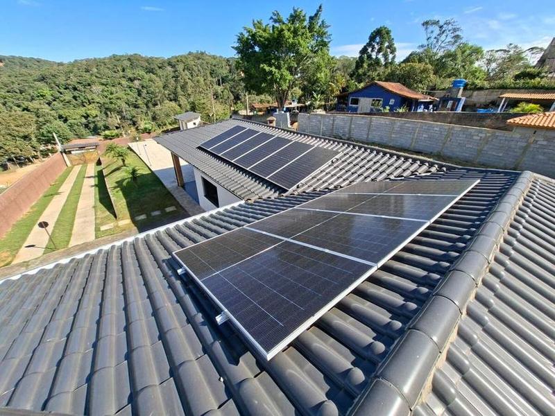 Painéis solares instalados em telhado com piscina ao fundo