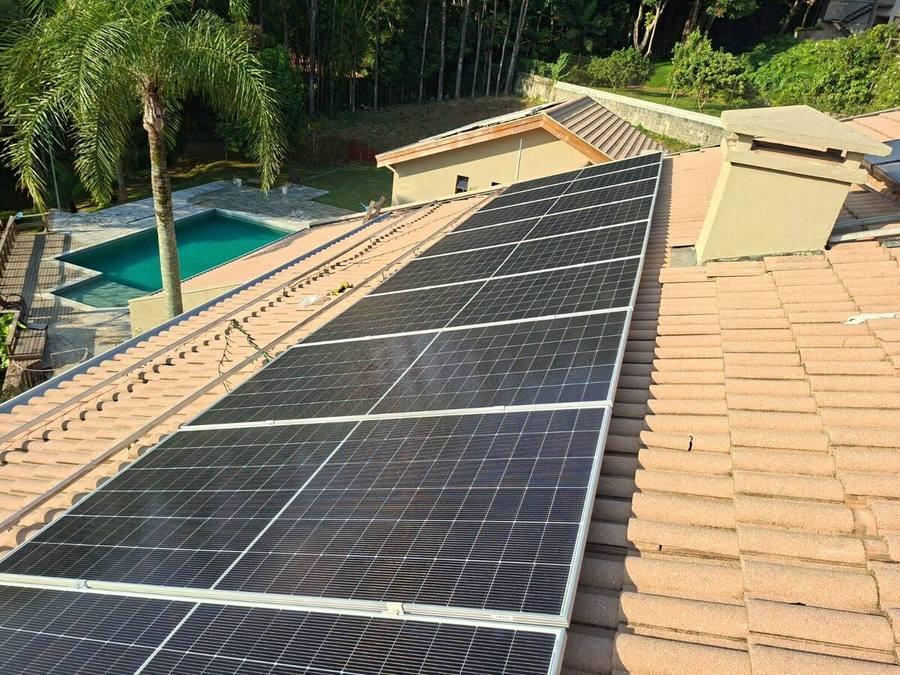 Painéis solares instalados em telhado residencial visto de cima